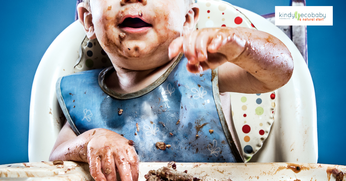 Baby in high chair covered in food