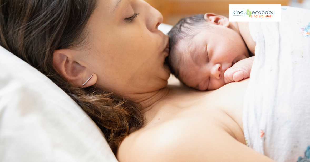 New born baby lying on mother and mothe is kissing it tenderly