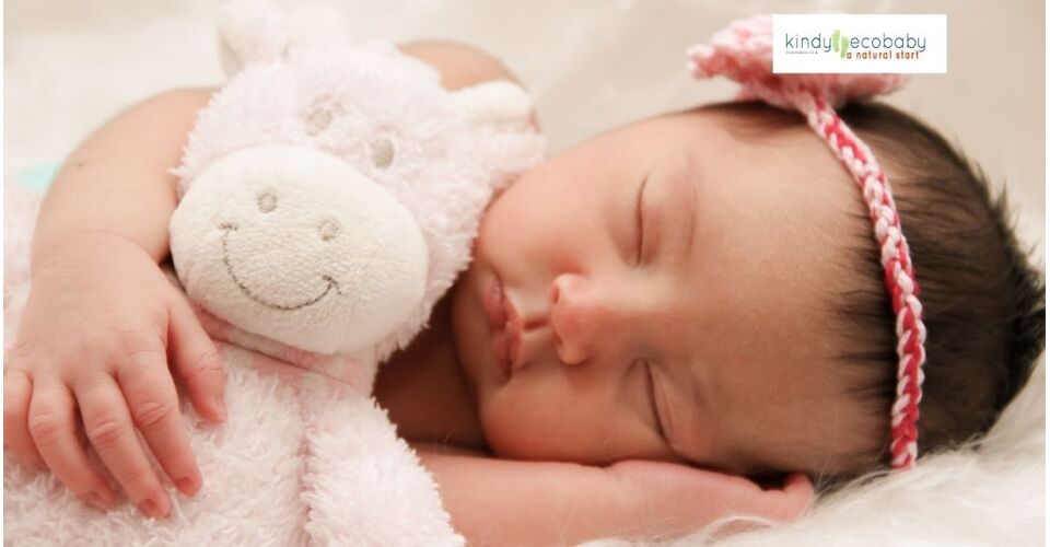 A peaceful baby sleeping soundly in a crib, surrounded by soft, eco-friendly bedding, under a gentle night light.