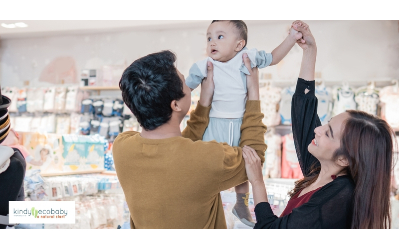 Cheerful parents and toddler in a grocery store, with the child happily embodying a stress-free and engaging shopping experience.